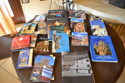 a table topped with lots of books on it at Villa Adriana B&B in Comiso
