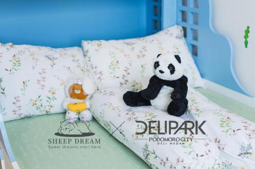 a stuffed panda bear sitting on a pillow in a crib at Delipark Mall 3 Bedrooms 3 Bathrooms 8-10 Pax Empire Premium Tower Level 28 in Medan