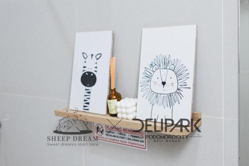 a shelf with a cat and a clock on it at Delipark Mall 3 Bedrooms 3 Bathrooms 8-10 Pax Empire Premium Tower Level 28 in Medan