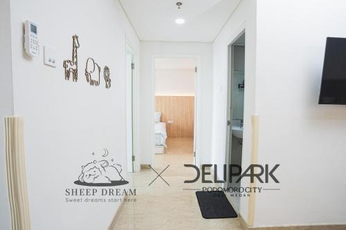 a living room with a hallway with a sign on the wall at Delipark Mall 3 Bedrooms 3 Bathrooms 8-10 Pax Empire Premium Tower Level 28 in Medan