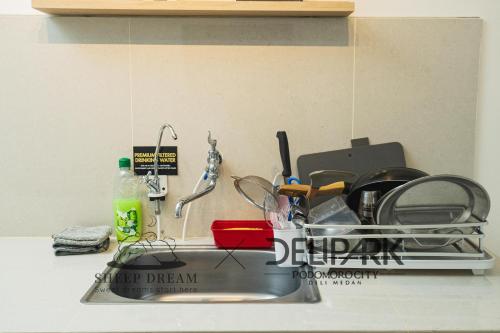 a kitchen counter with a sink with a lot of dishes at Delipark Mall 3 Bedrooms 3 Bathrooms 8-10 Pax Empire Premium Tower Level 28 in Medan