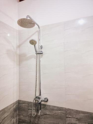 a shower with a shower head in a bathroom at Per villa in Unawatuna