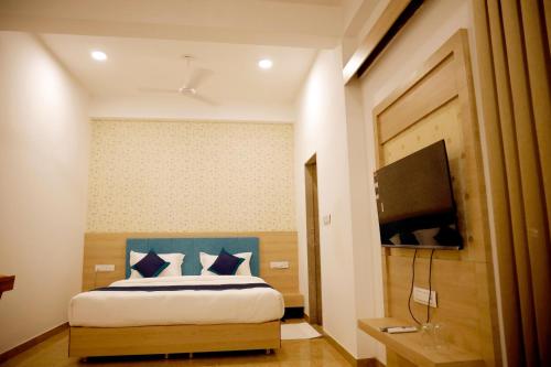 a bedroom with a bed and a television in it at Hotel The Urban Dream in Udaipur