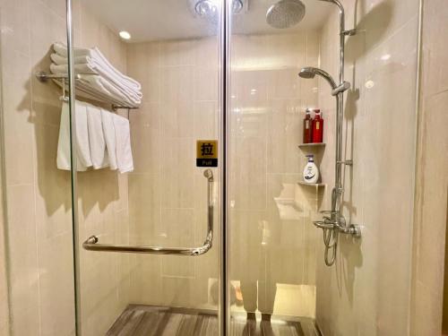 a shower with a glass door in a bathroom at Shanghai Lerongju Boutique Apartment Metro Line 8 20meter in Shanghai