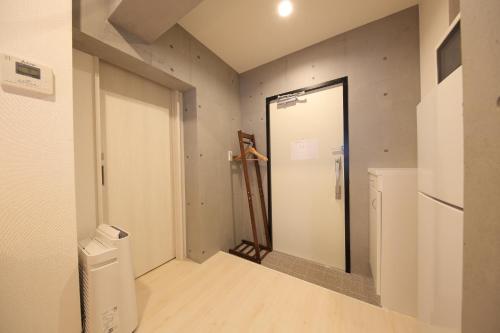 a hallway with a door to a laundry room at Tokyo Time Traveler 駅徒歩5分 暮らすように泊まれるホテル in Tokyo