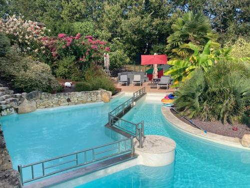 une grande piscine dans une cour avec dans l'établissement Villa Luna avec piscine dans un parc de 5200M en plein cœur du Périgord Noir, à Mauzens-et-Miremont