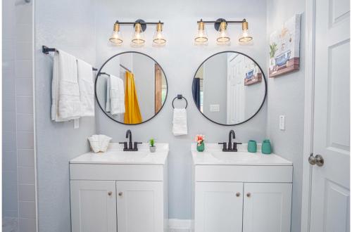 ein Badezimmer mit zwei Waschbecken und zwei Spiegeln in der Unterkunft Seize the Moment 4BR3BA Gem w Downtown Views in San Antonio