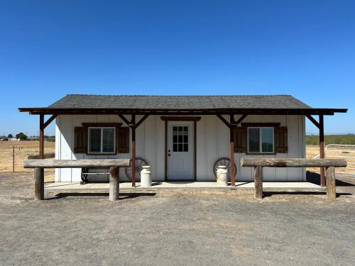 a small house with two benches in front of it at Adorable One Bedroom Cottage in Oakdale