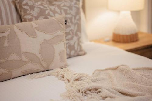 a bed with a pillow and a blanket on it at Stay Seaside Market 416 in Woolgoolga