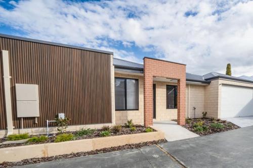 a brick house with a fence and a driveway at Convinient Cosy home with all around you! in Kelmscott