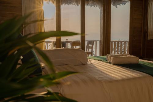 a bedroom with a bed with a view of the ocean at The Somayan Bungalows in Nusa Penida