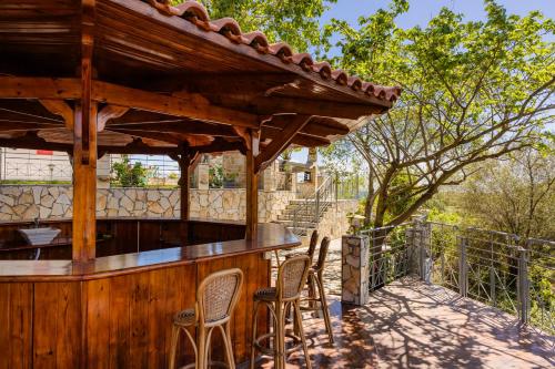 a wooden bar with chairs on a patio at Costa Avithos in Svoronata