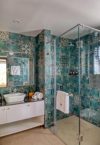 a bathroom with a glass shower and a sink at Graceful 1BHK Apartment by tisyastays in Candolim