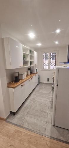 une cuisine avec des armoires blanches et un comptoir dans l'établissement Newly renovated 5min beach & 2min train station, à Vallauris