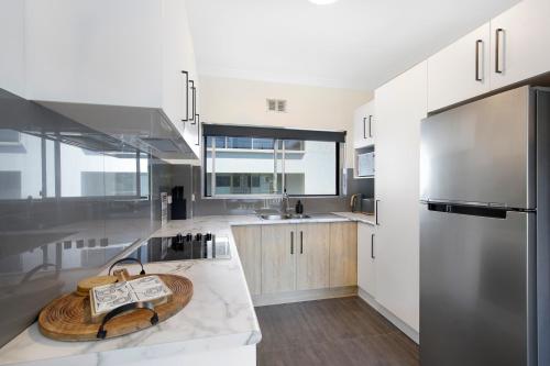 a kitchen with a wooden cutting board on a counter at Ocean Spray 8 in Coffs Harbour