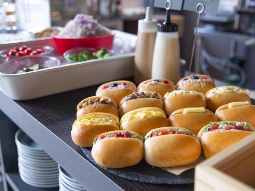 a tray of pastries on a table with plates at APA Hotel Hiroshima Ekimae Stadiumguchi in Hiroshima
