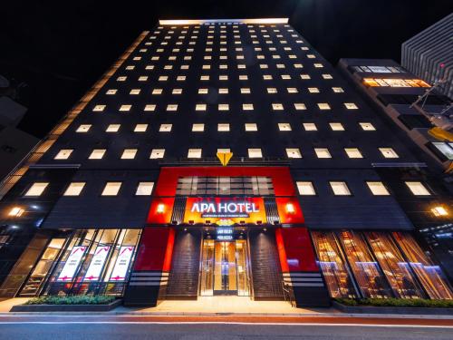 a tall building with a sign on the front of it at APA Hotel Hiroshima Ekimae Stadiumguchi in Hiroshima