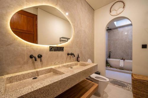 a bathroom with a sink and a toilet and a mirror at Casa Tua - Hidden Ubud Gem Views in Ubud