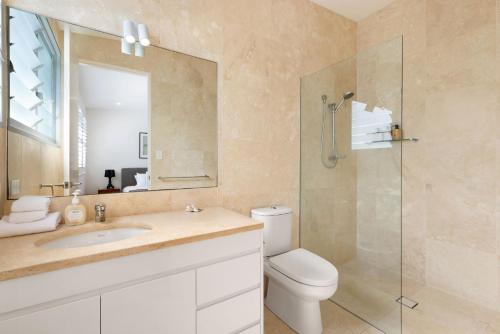 a bathroom with a toilet and a sink and a shower at Lane by the Bay - Centrally located 2 bed modern Townhouse in Byron Bay