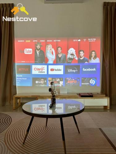 a large screen with a tv in a room with a table at Klebang 7 Spacious Luxury 6BR Villa By Nestcove in Melaka