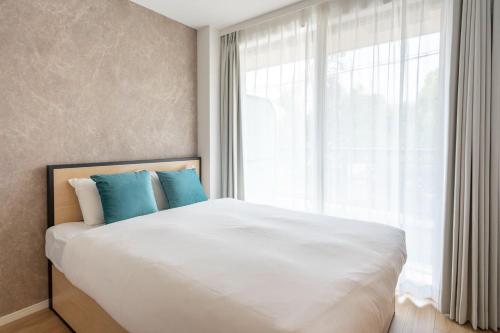 a bedroom with a large white bed with blue pillows at La grace Akane in Osaka