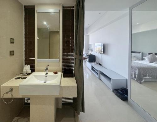 a bathroom with a sink and a bed at Barry Boutique Hotel Sanya in Sanya