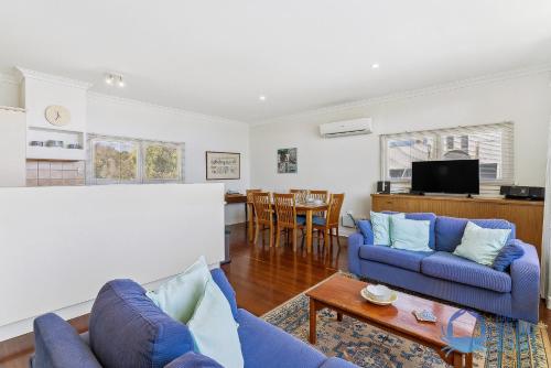 a living room with two blue couches and a table at Mandurah Overlooking The Marina in Mandurah