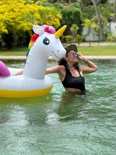 a woman in the water next to a unicorn float at Cozy Villa in Hikkaduwa