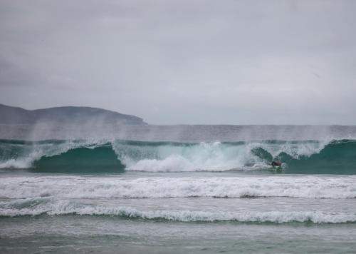 a surfer riding a large wave in the ocean at Poppy's Place - Denmark in Denmark