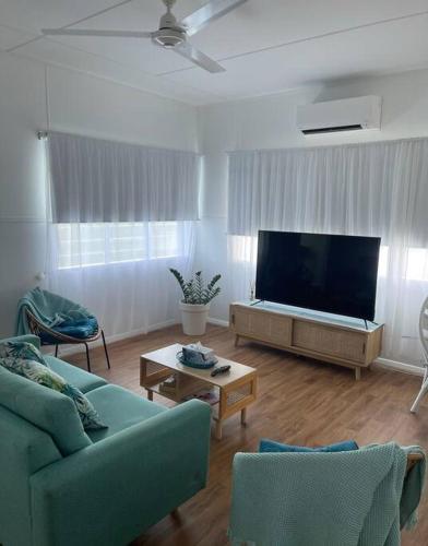 a living room with a couch and a flat screen tv at Salt Apartment in Mossman