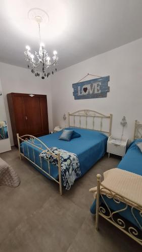 a bedroom with two beds and a chandelier at Tana della Lavanda in Montefiorino