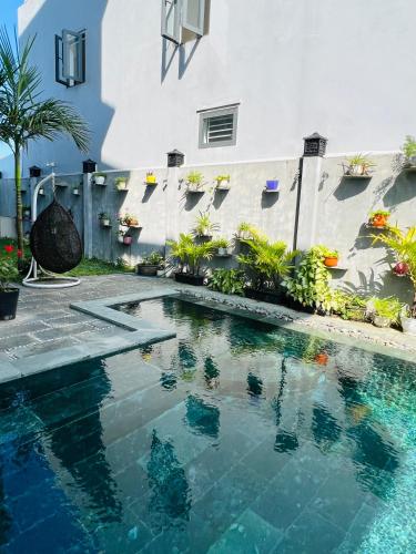 a swimming pool in front of a building at De Mai’s apartment in Hoi An