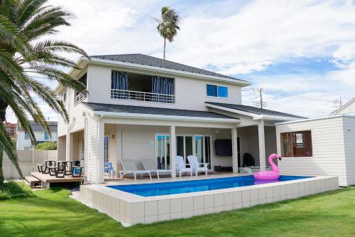 a house with a pink flamingo in front of it at SEADINERS Beachfront Villa 99 in Ichinomiya