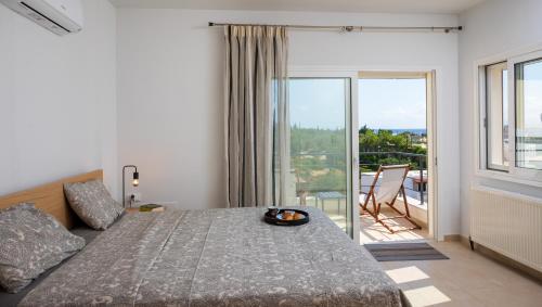 a bedroom with a bed with a view of a balcony at Ormos Sea View Apartment in Agios Nikolaos