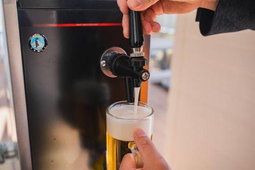 a person pouring a beer into a glass at SEADINERS Beachfront Villa 99 in Ichinomiya
