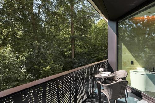 a patio with two chairs and a table on a balcony at The Dolder Grand - City and Spa Resort Zurich in Zürich