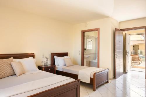 a bedroom with two beds and a balcony at Belle View Hotel - Sea View & Sunset in Mánganos