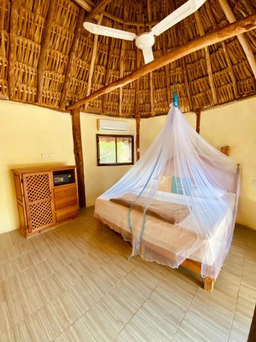 a bedroom with a bed with a mosquito net at Cabanas Jaalkab in Chelem