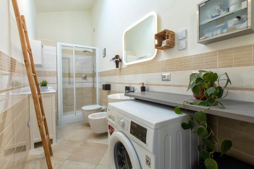 een badkamer met een wasmachine en droger bij Non dire Gatto - Elegant Rooftop in Alghero