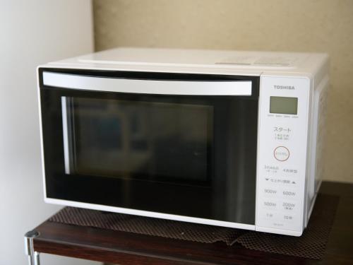 a microwave oven sitting on top of a wooden table at Business Hotel Okadaya Bayside in Toyohashi