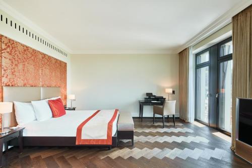 a hotel room with a bed and a desk at The Dolder Grand - City and Spa Resort Zurich in Zürich