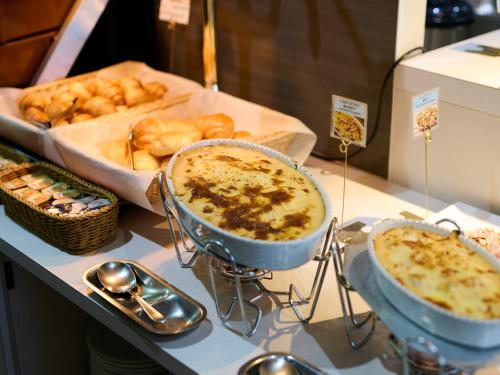 a buffet with two dishes of food and bread at Business Hotel Okadaya Bayside in Toyohashi