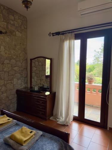 a bedroom with a bed and a mirror and a window at Evilion Ktima Argyropoulou in Katarrákhion