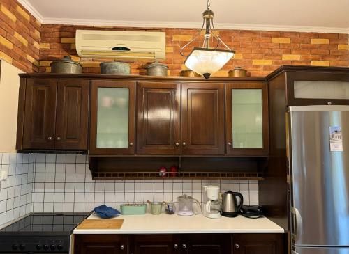 a kitchen with wooden cabinets and a stainless steel refrigerator at Evilion Ktima Argyropoulou in Katarrákhion