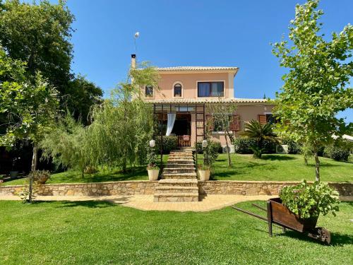 a house with a staircase in a yard at Evilion Ktima Argyropoulou in Katarrákhion