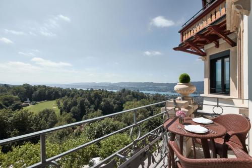 a balcony of a house with a table and chairs at The Dolder Grand - City and Spa Resort Zurich in Zürich