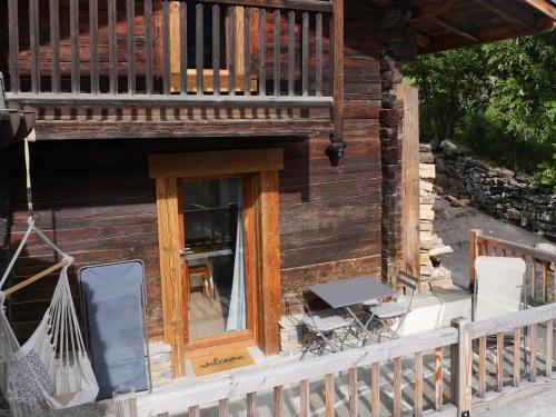 a porch of a log cabin with a balcony at La ferme d'Hauteluce - Chalets in Hauteluce