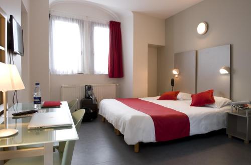 Pokój hotelowy z dużym łóżkiem i biurkiem w obiekcie Hôtel du Musée de l'Eau w mieście Pont-en-Royans