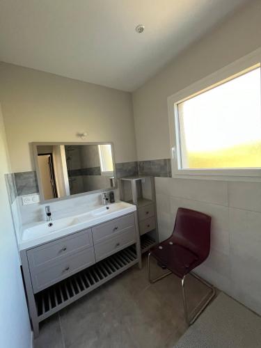 une salle de bain avec un lavabo, un miroir et une chaise dans l'établissement Gte De Landuzire, House-apartment sleeps 6, à Saint-Genest-Lerpt