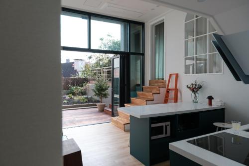 a kitchen with a large window and a staircase at Blik Stille Hyochang 101 Yongsan Premium House in Seoul